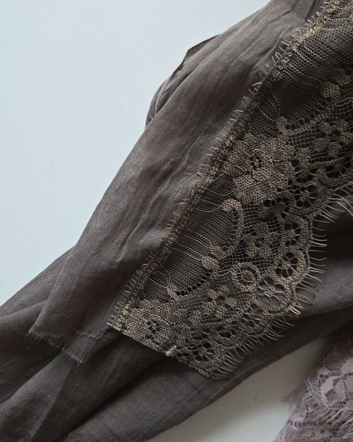 Brown fabric with lace detailing on a light background
