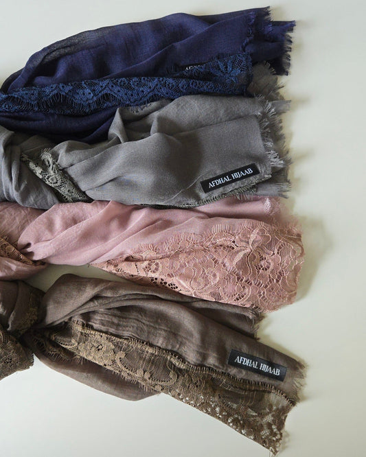Four scarves in brown, pink, gray, and blue on a white background