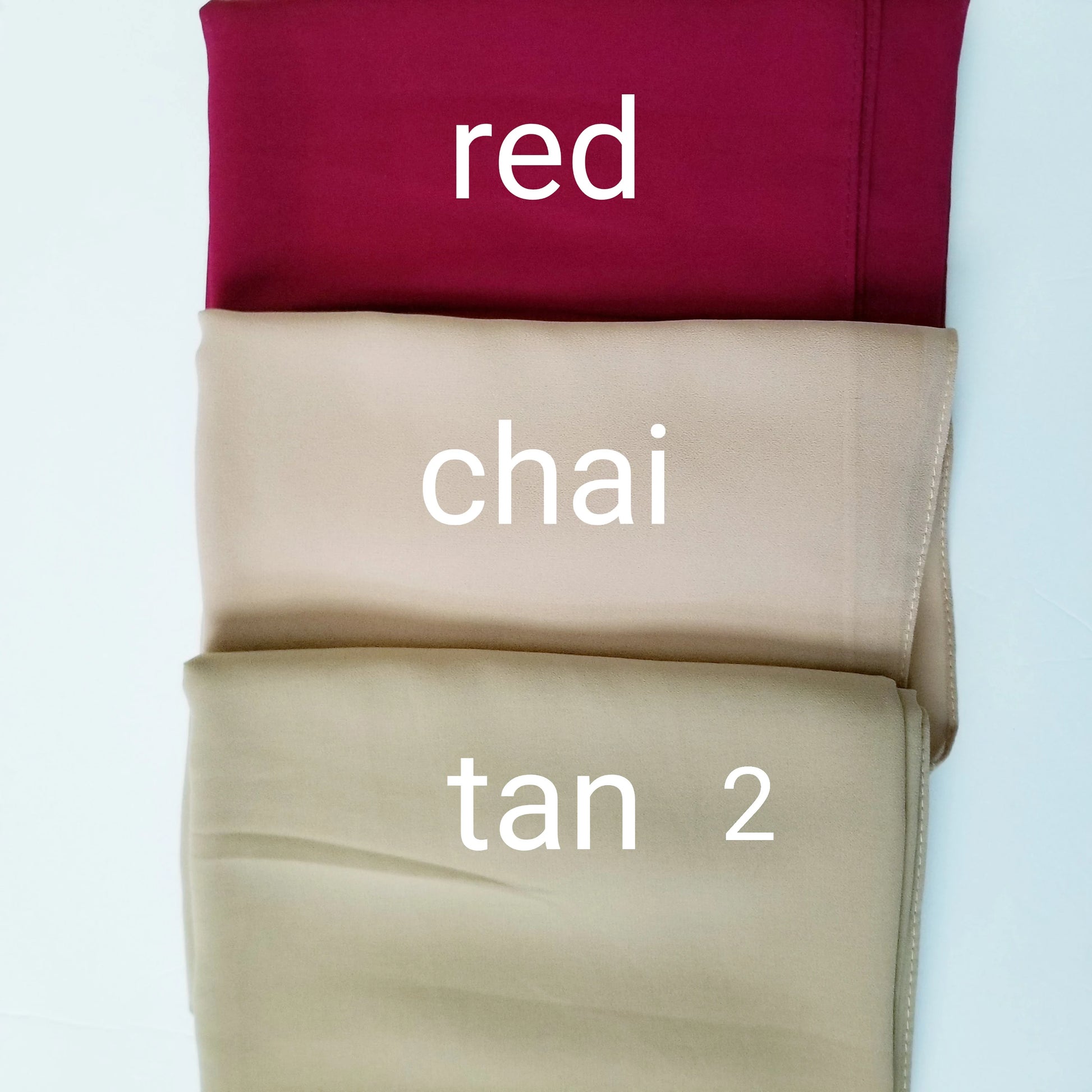 Three folded chiffon hijabs labeled 'red', 'chai', and 'tan 2' on a light blue background.